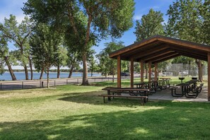 Un parc doté de tables de pique-nique et d’un pavillon abrité offrant une vue sur une étendue d’eau.