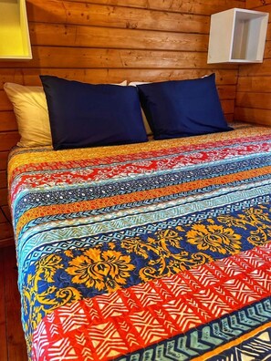 A bed with a colorful patterned bedspread and two pillows. - Peaceful Lakefront Cabin with Loft, Beach Access & Sunset Views in Buchanan Dam, Texas (Buchanan Dam)