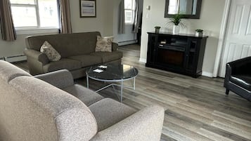 A living room with a sofa, a coffee table, and a fireplace.