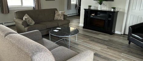 A living room with a sofa, a coffee table, and a fireplace.