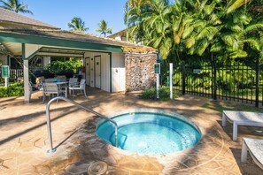 A pool area with a stone deck, lounge chairs, and a covered seating area. - Regency at Poipu Kai 823 | Spacious 3BR Townhome Near Poipu Beach (Koloa)