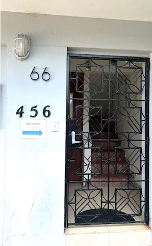 A building entrance with a metal gate, a number '456' sign, and an arrow pointing to apartments '4, 5, & 6'. - Stay Near Everything & Beach - Walkable Condado (San Juan)