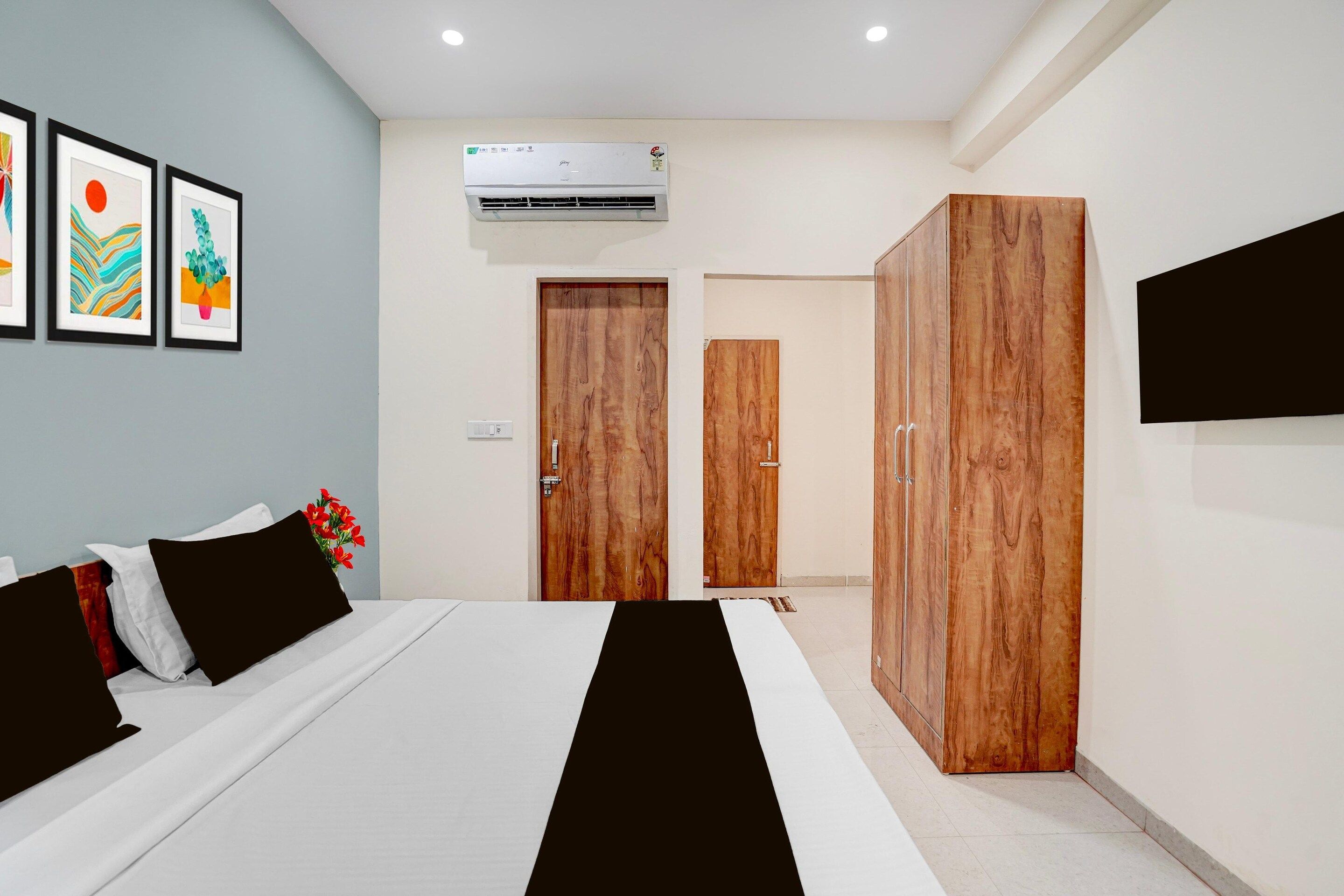 A hotel room with a bed, wardrobe, and air conditioning unit.