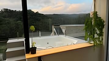 Um interior moderno com uma grande janela com vista para uma paisagem montanhosa.