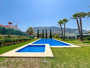 A swimming pool with a clear view of the surrounding landscape, including mountains and a modern building. - Modern townhouse in Dénia – all-inclusive (Denia)