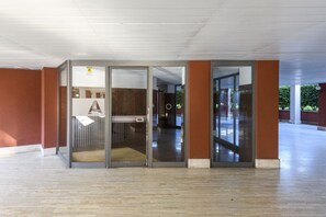 A spacious indoor area with a glass door entrance, a visible toilet, and a corridor leading to another room. - Lodi, 65 – Your Milan Base (Milan)