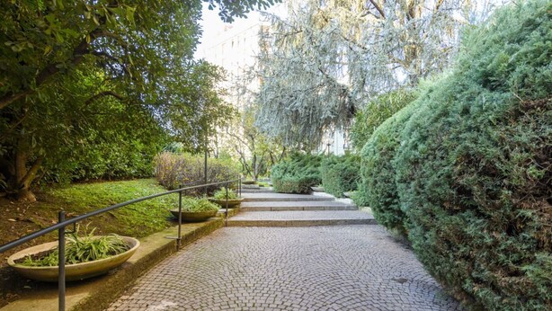 A paved pathway with a metal railing, surrounded by lush greenery and trees. - Lodi, 65 – Your Milan Base (Milan)