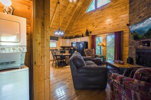 A cozy cabin interior with a living room, kitchen, and dining area. - A Time to Remember -Private Hot Tub • Game Room • Resort Pools (Sevierville)
