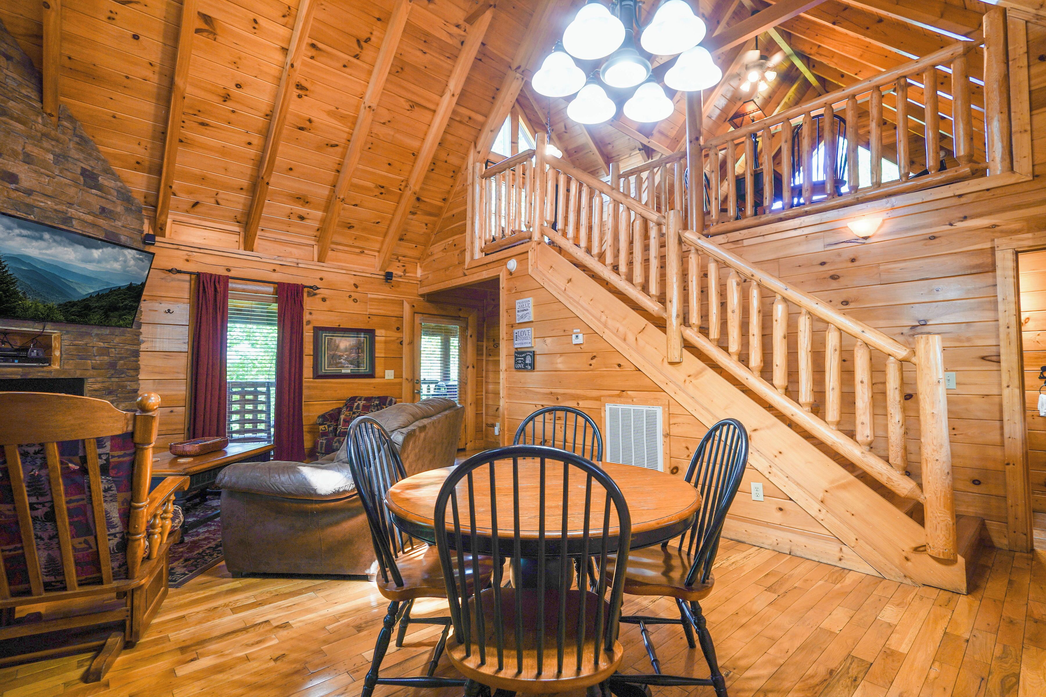Un interior de madera con comedor, una escalera y vistas al exterior.