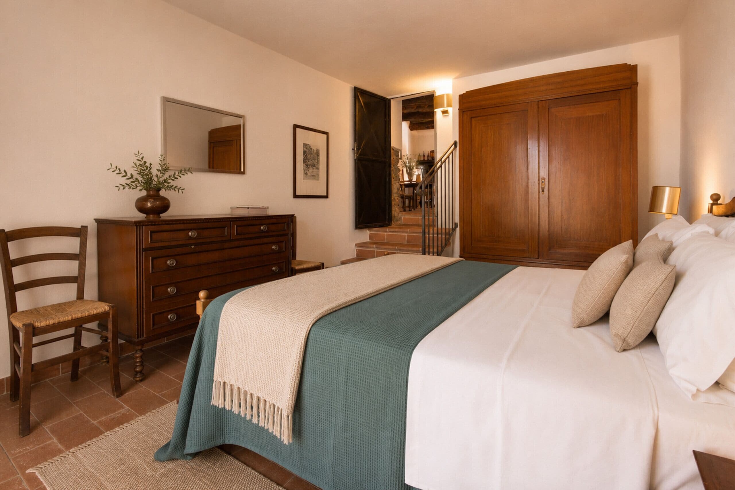 A bedroom with a bed, dresser, chair, and a large wardrobe.