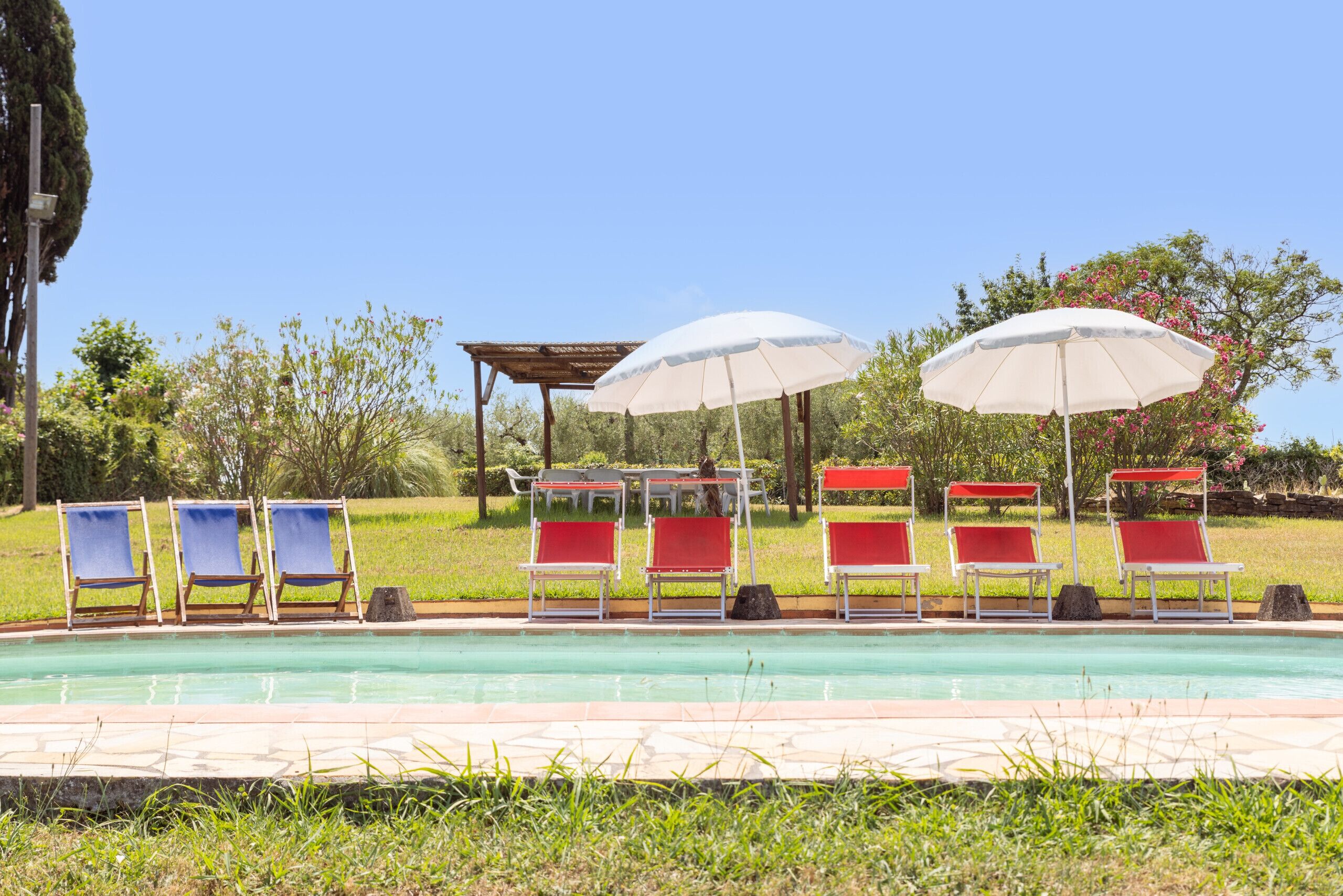 A poolside area with lounge chairs and umbrellas.