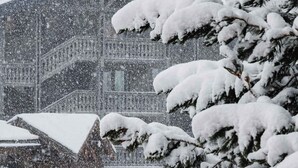 Ein Gebäude mit schneebedeckten Dächern und Bäumen, das eine Winterstimmung vermittelt.