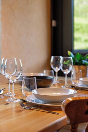 A dining table set with plates, glasses, and cutlery, with a window in the background. - “V12” by Versant Collection (Les Belleville)
