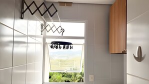 Een badkamer met een raam, een douche en een houten kast.