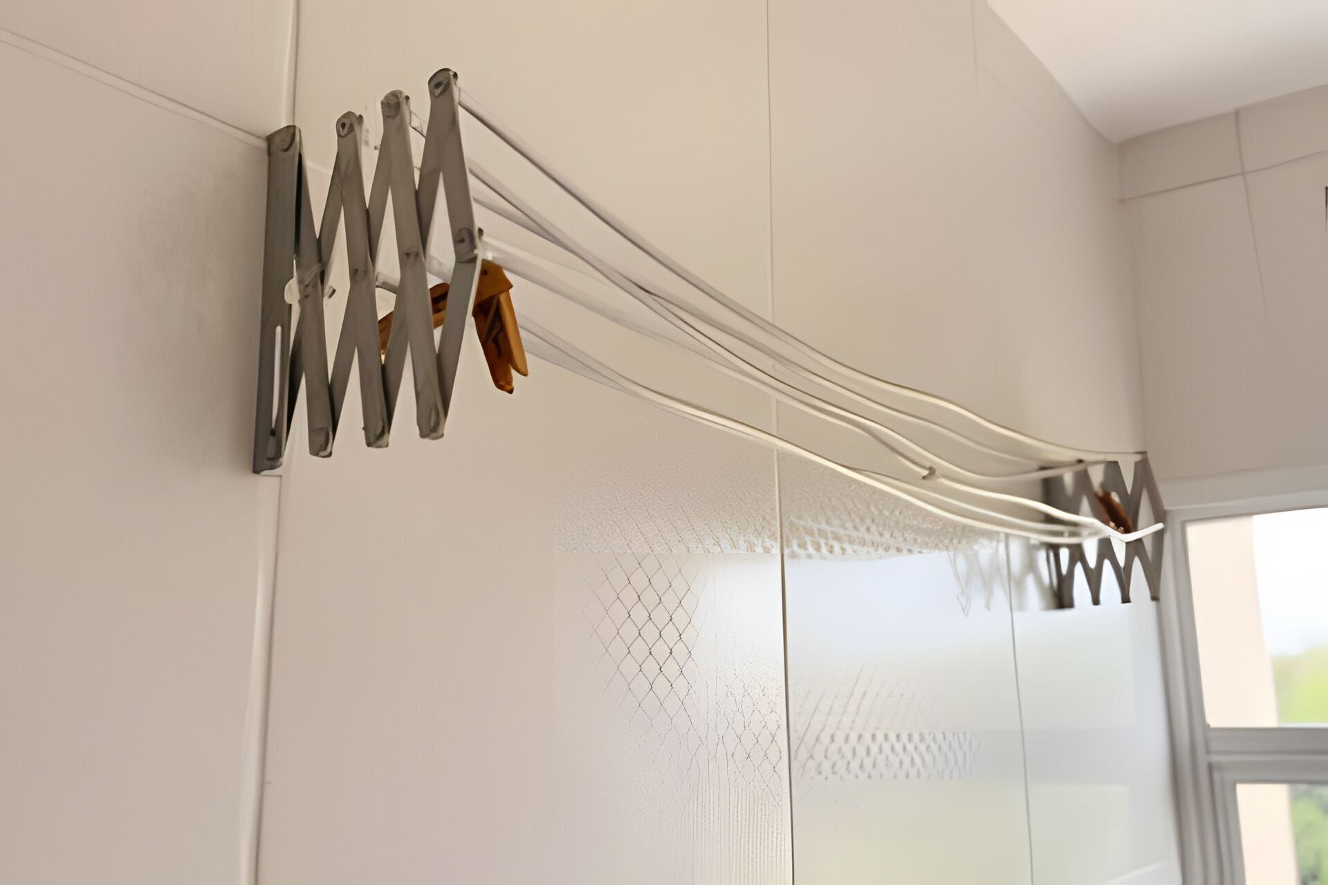Een modern interieur met een witte muur en een metalen rek met meerdere haken.