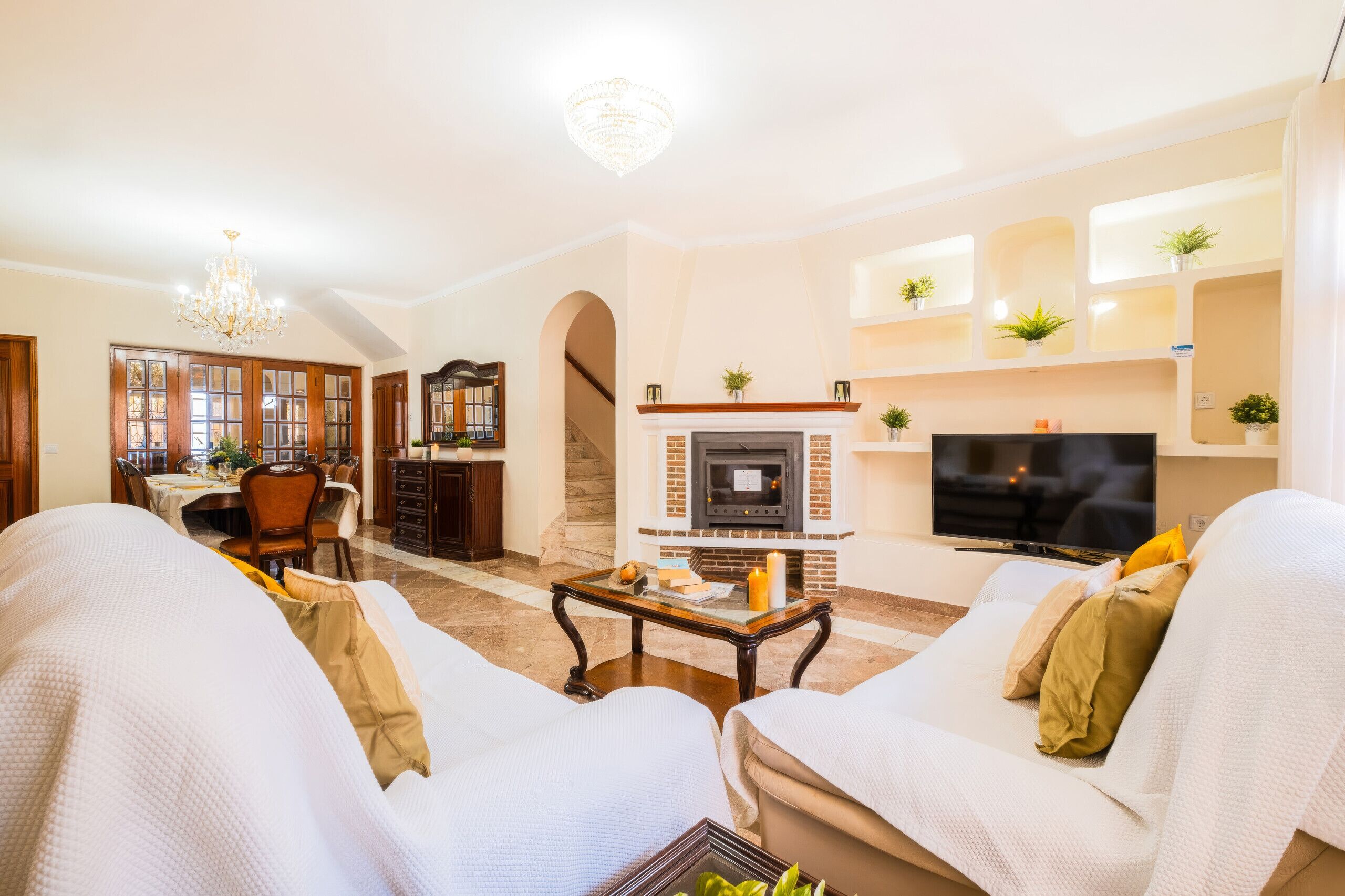 Una sala de estar con chimenea, televisor y zona de estar.