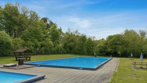 A rectangular swimming pool with a wooden deck surrounding it, benches, and a gazebo. - Holiday home with garden and wildlife in Gjern (Truust)