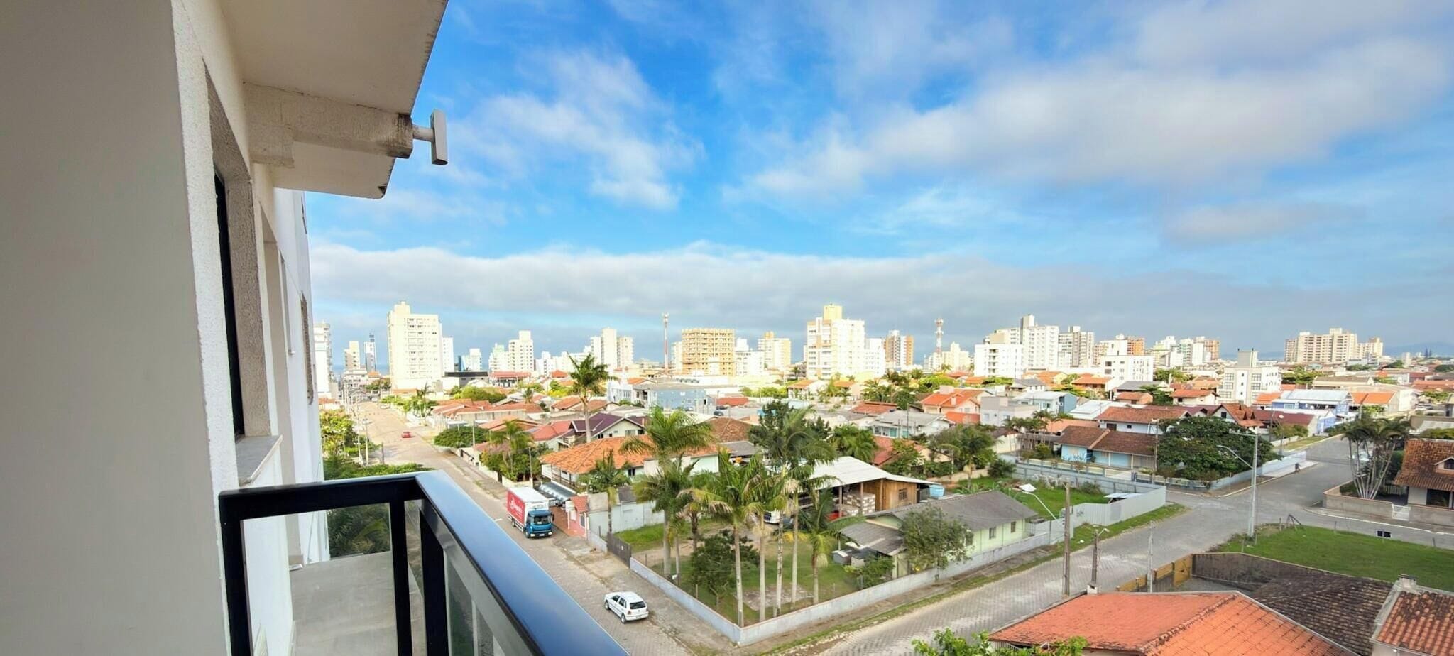 A residential area with a view of a city skyline, including high-rise buildings and a mix of residential and commercial structures.
