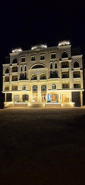 Ein mehrstöckiges Hotel mit einer symmetrischen Fassade, großen Fenstern und einem zentralen Eingang.