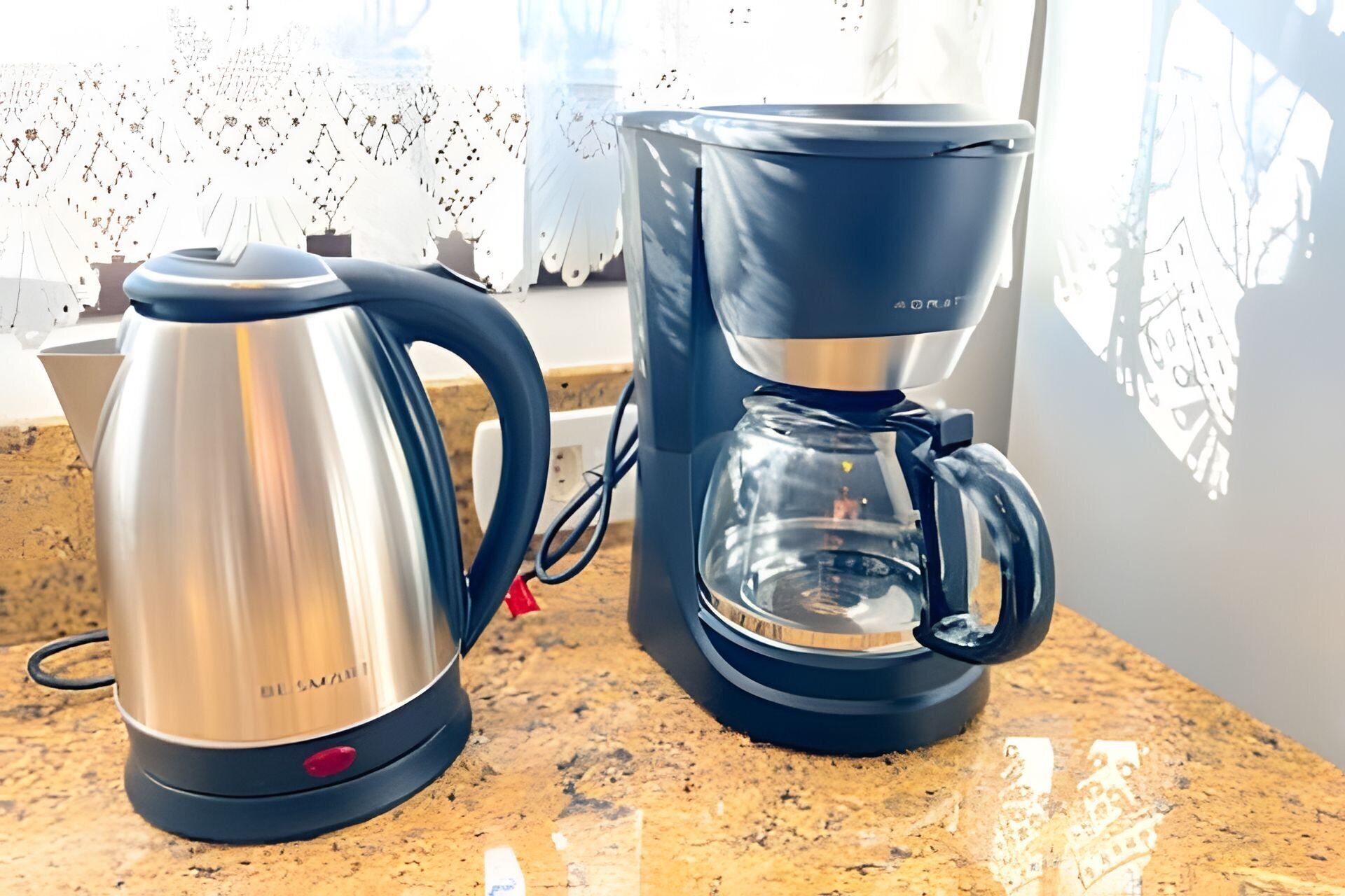 A coffee maker and a kettle on a countertop.