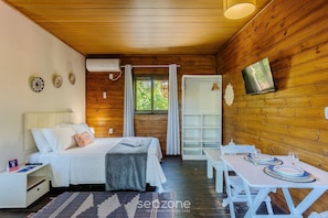 Una habitación acogedora con cama, mesita de noche y una mesa para dos personas.