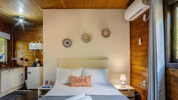 A cozy bedroom with a bed, bedside table, lamp, and decorative wall art.