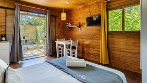 Una habitación de cabaña de madera con cama, una mesa y un televisor.
