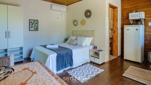 Un dormitorio con cama, mesita de noche, armario y kitchenette.