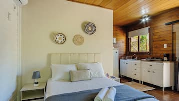 Un dormitorio con cama, mesita de noche, lámpara y adornos en la pared.