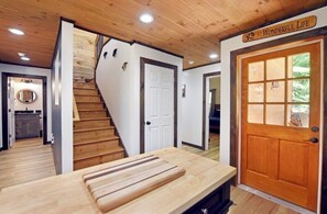 A wooden interior with a staircase, a door with a window, and a sign that reads 'Wonderful Life'. - Mountain Melody- Cozy 3-bedroom cabin with AC in Ellijay- Hot Tub + EV Charger (Ellijay)