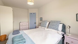 A bedroom with a bed, bedside table, lamp, and a door. - Host & Stay | The Hidden House (Dawlish)