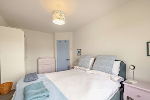 A bedroom with a bed, bedside table, lamp, and a door. - Host & Stay | The Hidden House (Dawlish)