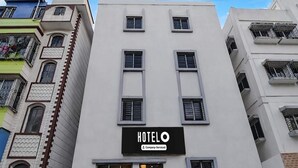 A hotel building with a sign reading 'HOTELO Company-Serviced' and a staircase leading to the entrance. - Deluxe Hotel Bidisha (Kanthi)