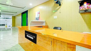 Una mesa de recepción con un cartel que indica que es administrada por OYO.