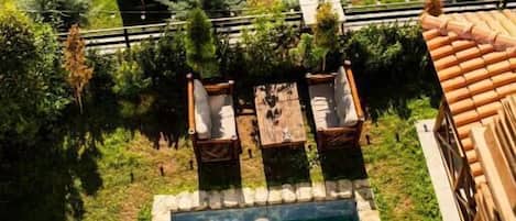Vista aérea de una propiedad con piscina, mobiliario de exterior y una zona cubierta.