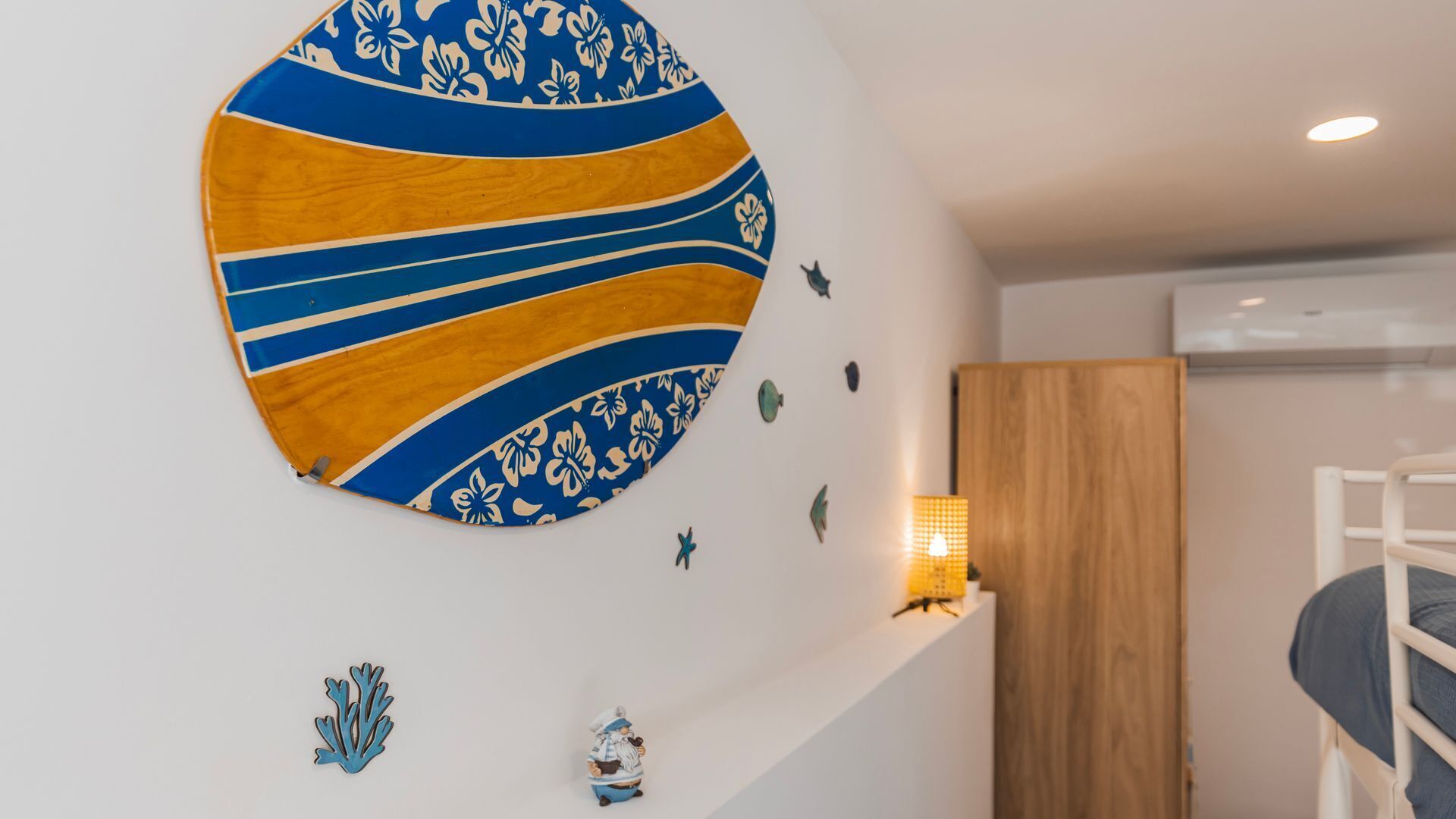 Een kamer met een stapelbed, een rond kunstwerk aan de muur en kleine decoratieve objecten.