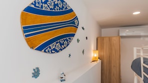 Ein Zimmer mit einem Etagenbett, einem wandmontierten runden Kunstwerk und kleinen dekorativen Accessoires.