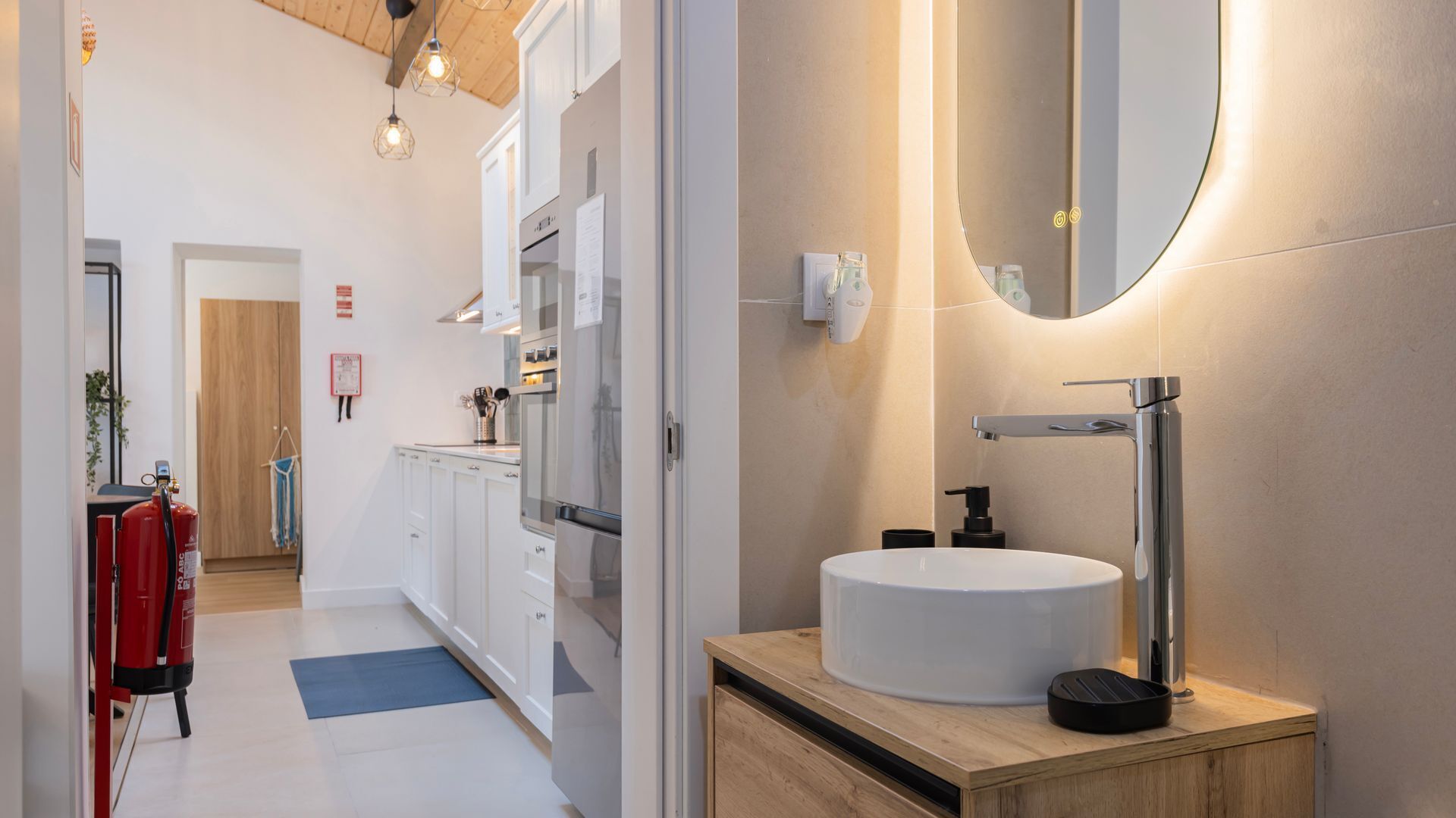 Une cuisine moderne avec des armoires blanches, une hotte en acier inoxydable et un plan de travail en bois.