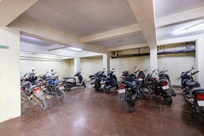 A parking garage with multiple rows of parked motorcycles.