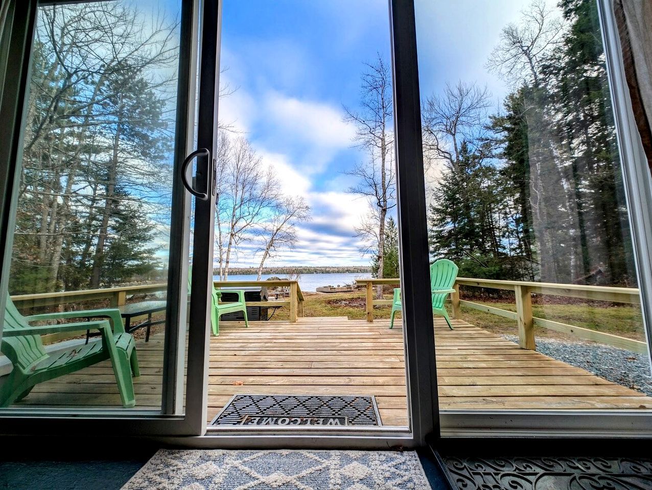 A deck with outdoor seating and a view of a forested area.