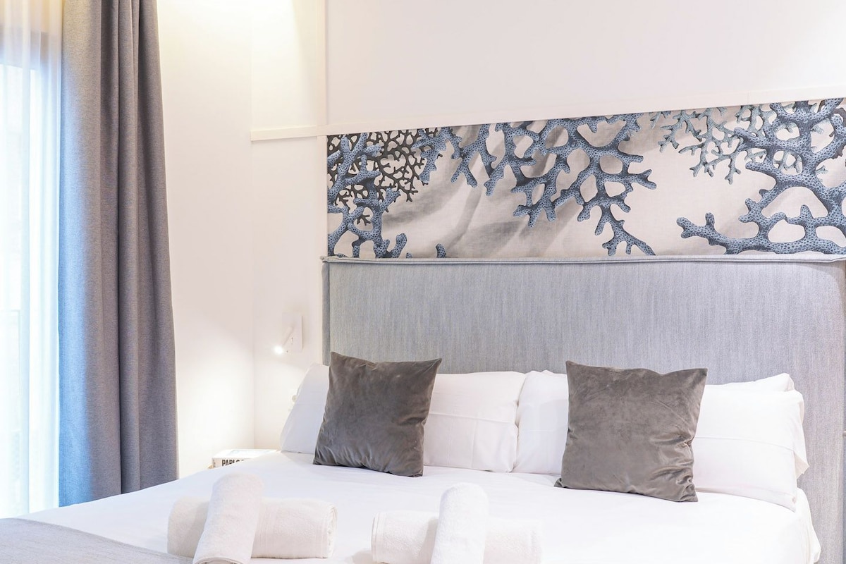 Ein Hotelzimmer mit einem Bett, Kissen und einem Kopfteil mit Korallenmuster.