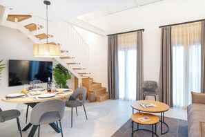 Ein modernes Wohnzimmer mit Treppe, Essbereich und Sitzgelegenheiten.