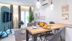 Ein modernes Wohnzimmer mit Essbereich, Fernseher und Pflanze.