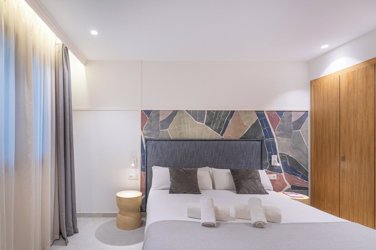 Ein modernes Hotelzimmer mit einem großen Bett, einem Holzschrank und einer Wanddekoration.