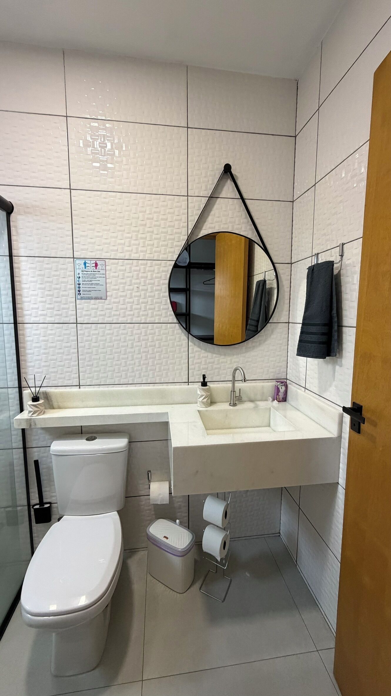A modern bathroom with a toilet, sink, and mirror.