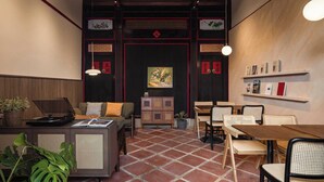 Un interior de estilo tradicional con una zona de comedor, un sofá, una mesa de centro y una estantería.