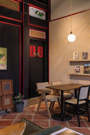 Un comedor con una mesa y sillas de madera, una lámpara colgante y detalles decorativos en las paredes.