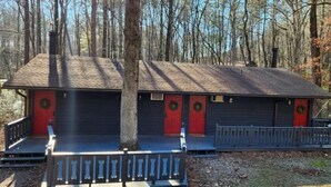 A cabin with a porch and two doors, surrounded by trees. - The Lost Compass (Sautee Nacoochee)