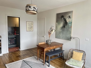 A dining area with a wooden table, bench, and a vase with dried flowers. - Parisian apartment on courtyard (Paris)