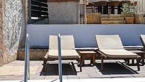 A swimming pool with lounge chairs and a stone wall. - Luxury Villa Blu with pool by the beach (Okrug Gornji)